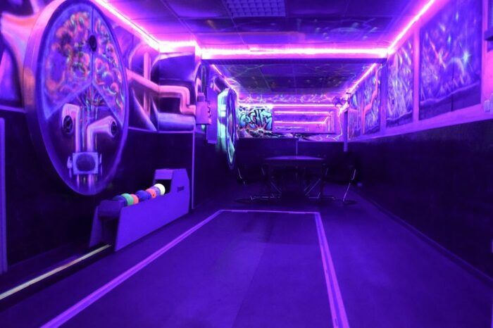 Schwarzlicht-Kegelbahn mit Neon-Decke und Kugelrücklauf